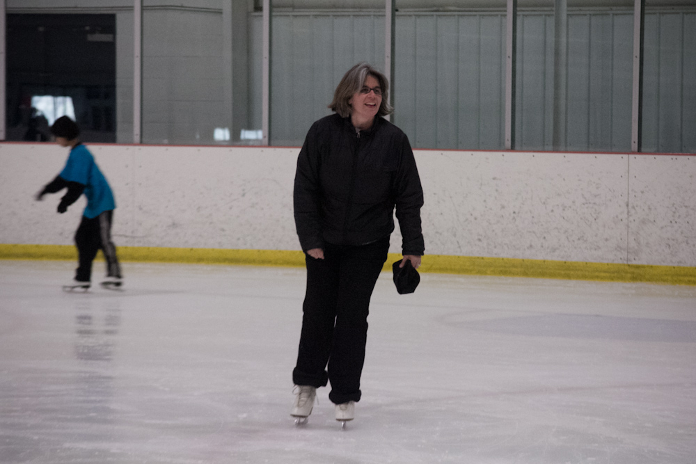 two people on ice skating in an arena