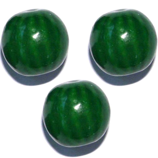 four green color candies sitting on a white surface