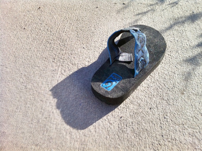 a pair of gray sandals are laying on the ground