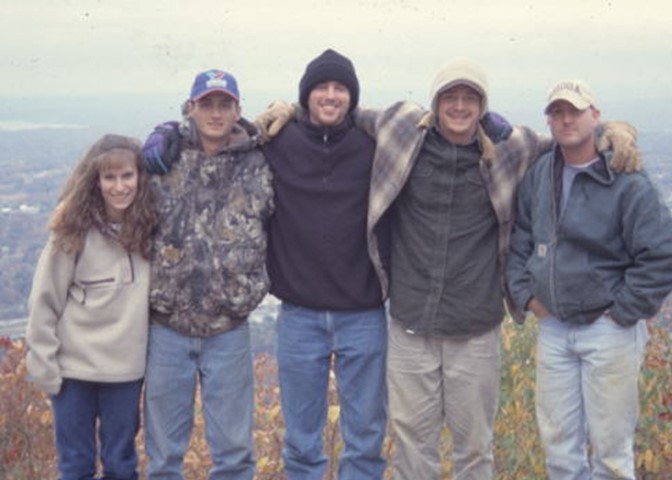 six people are standing on the edge of a hill
