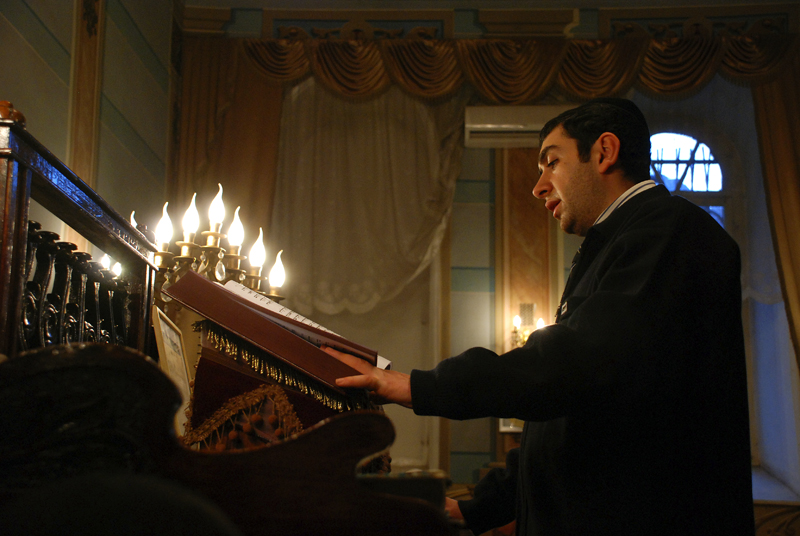 a man in a suit and tie holding a box with several candles