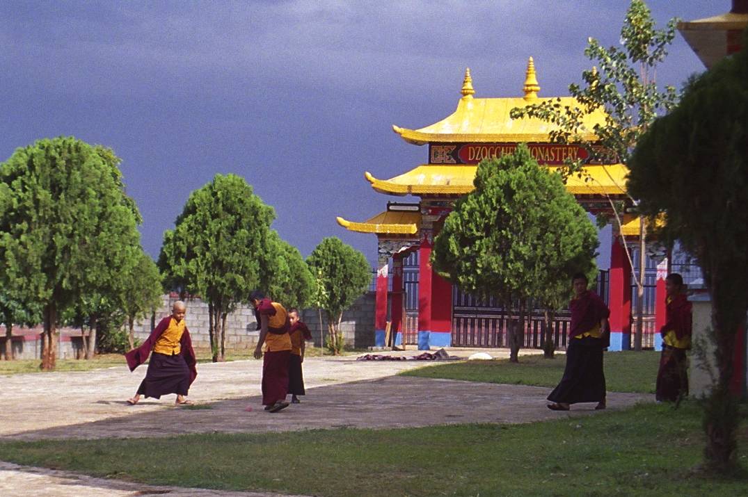 three people dressed in oriental attire walking toward a building