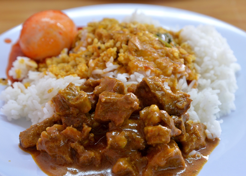a plate topped with meat, rice and carrots