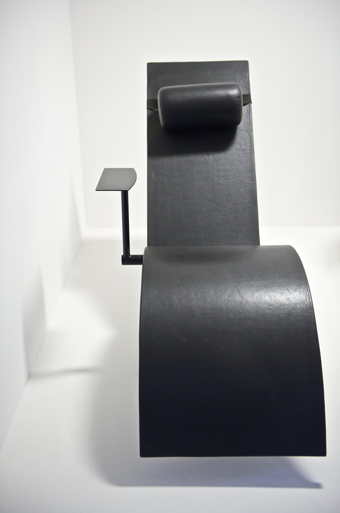 the chair is made with black leather, and has a square leg