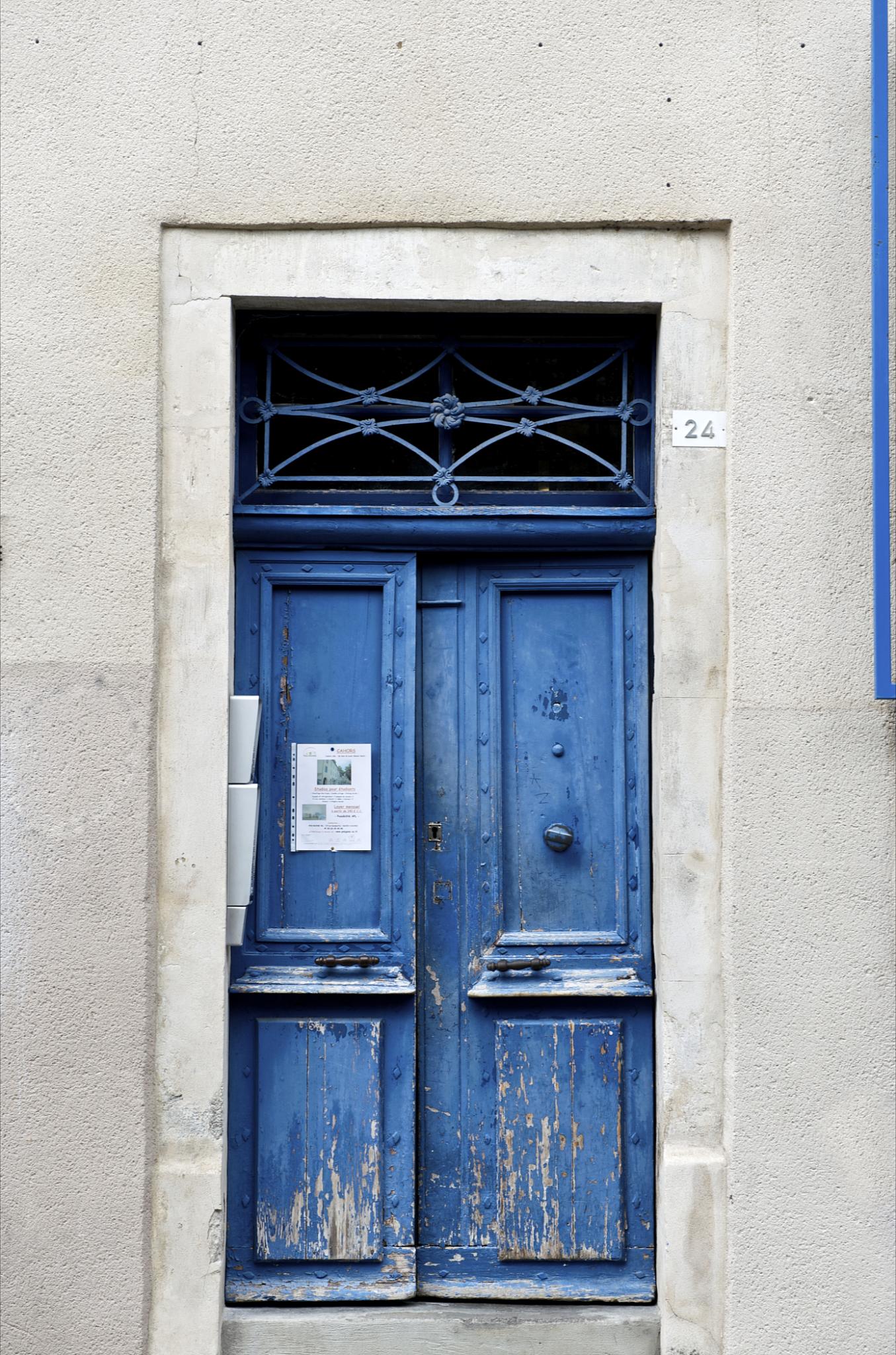 blue door with iron bars on two sides of building