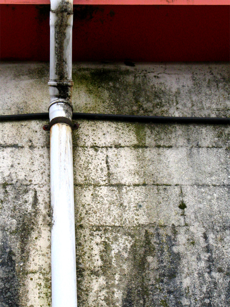 a white pipe hanging off the side of a building