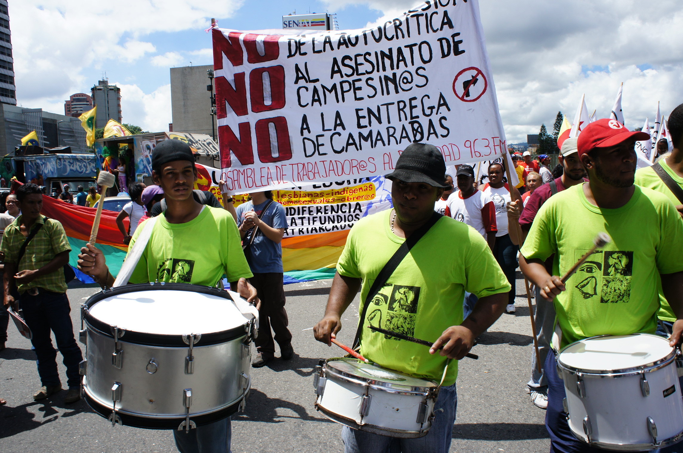 men holding steel drums and wearing green shirts