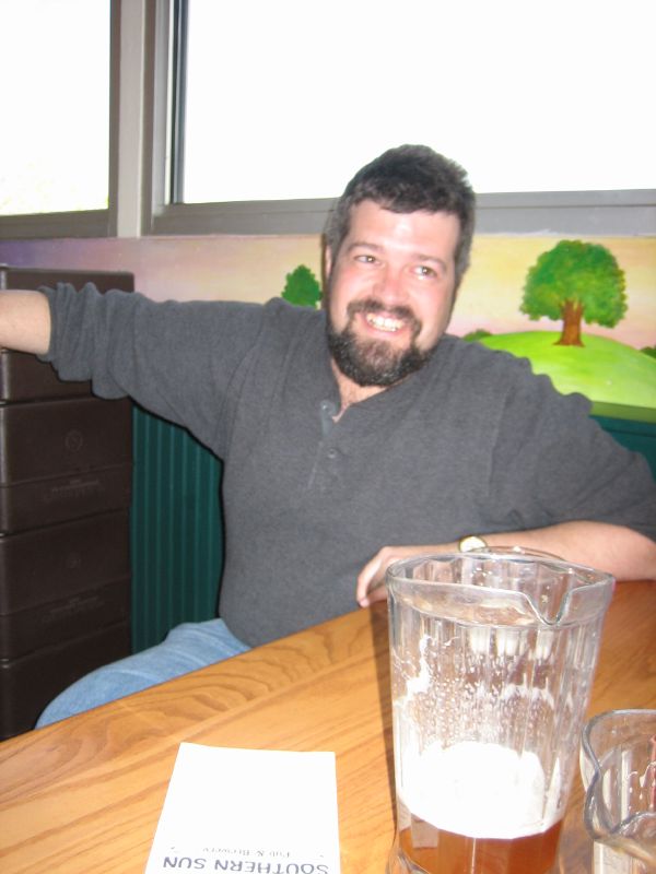 a man sitting at a table with two glasses