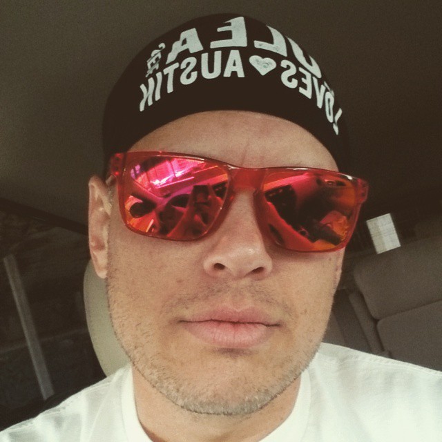 this is a man wearing red sunglasses, and a black and white baseball cap