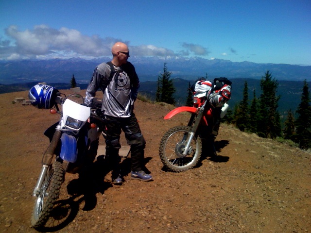 the two men are ready to ride their bikes on the mountain