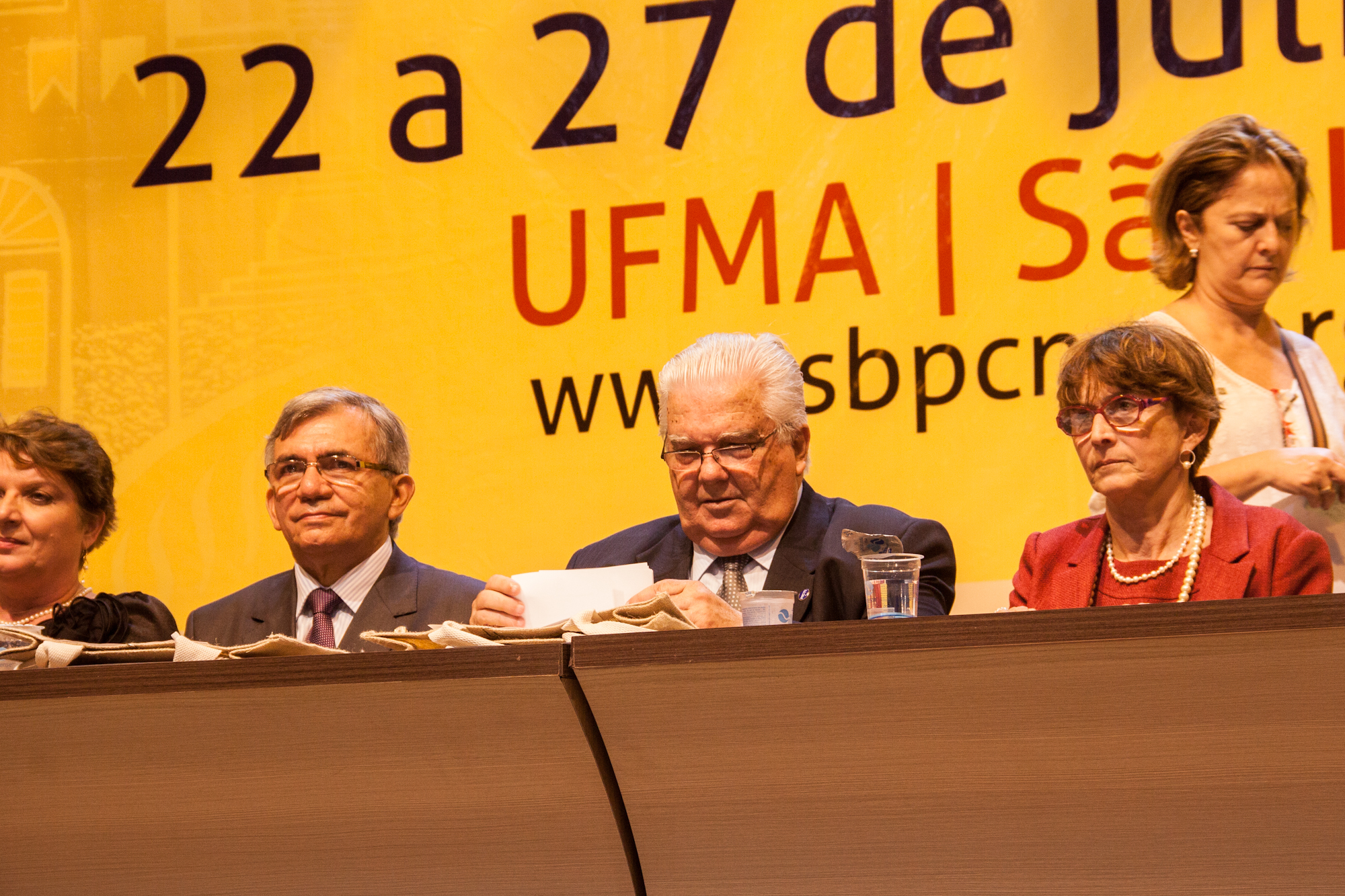 four people standing at a panel during a speech