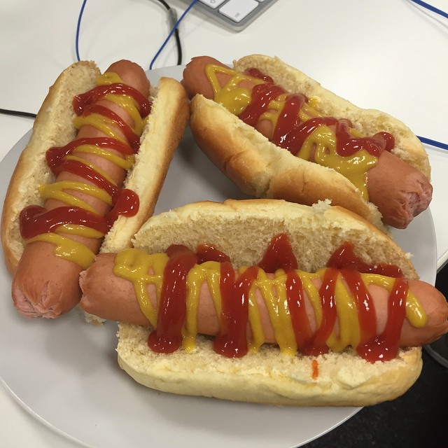 three  dogs with ketchup and mustard on a plate