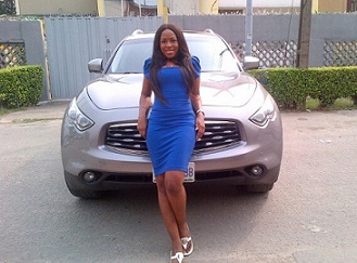 the woman poses next to her silver sports car