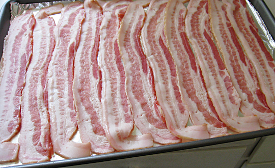 raw bacon in the middle of a sheet of foil on a counter