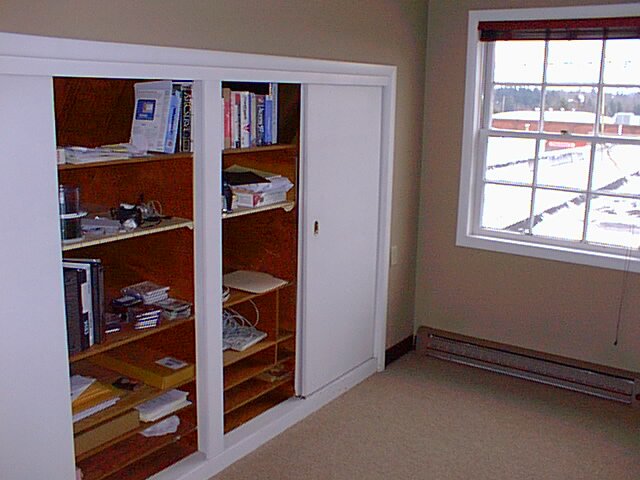 an empty room with two large cupboards containing books and dvds