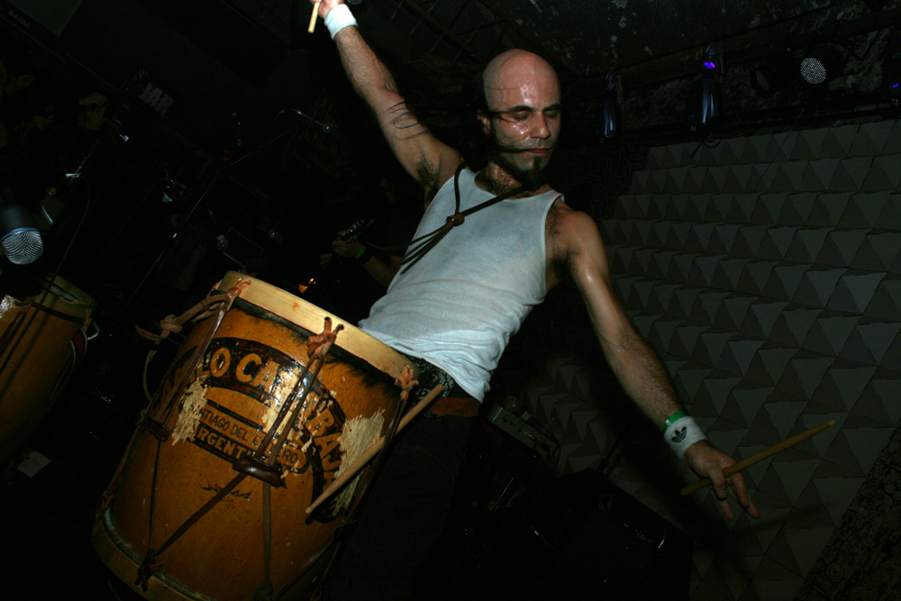 a man playing a drum in front of a stage