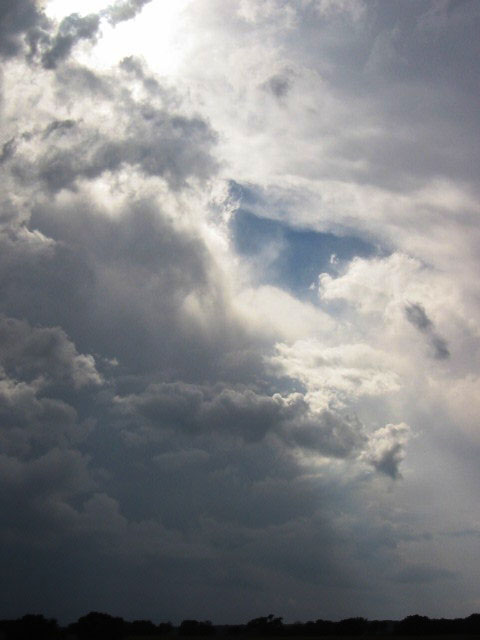 a dark cloudy sky is behind a single kite