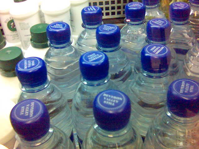 several bottles of bottled water sit on the counter