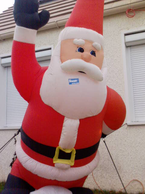 santa clause balloon sitting on the corner of a building