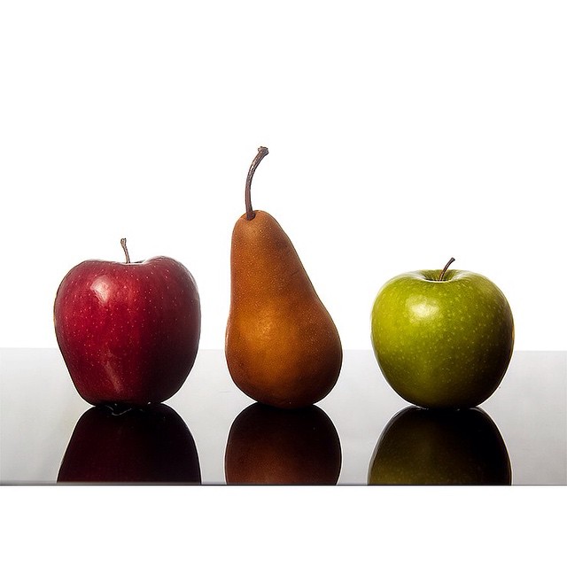three apples and two pears on a table