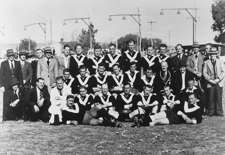 a group of men in sports uniforms posing for a po