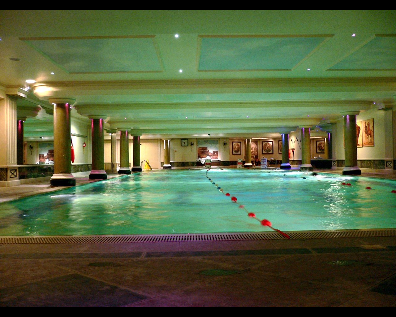 a large indoor swimming pool in an el with large pillars