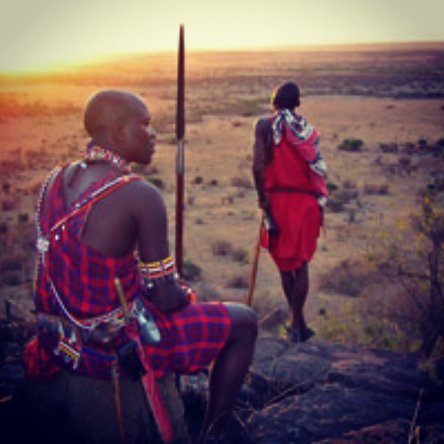 a man with a stick watching another man in a field