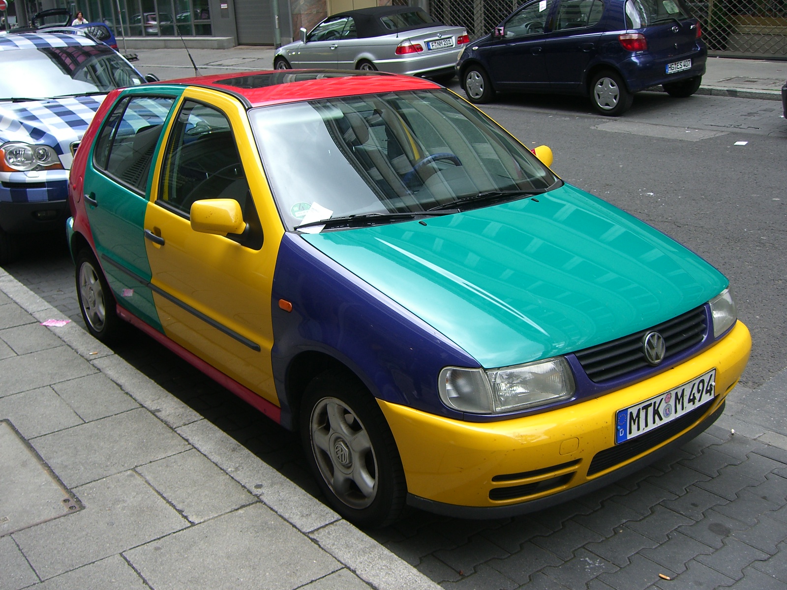 a colorful car is parked next to other cars