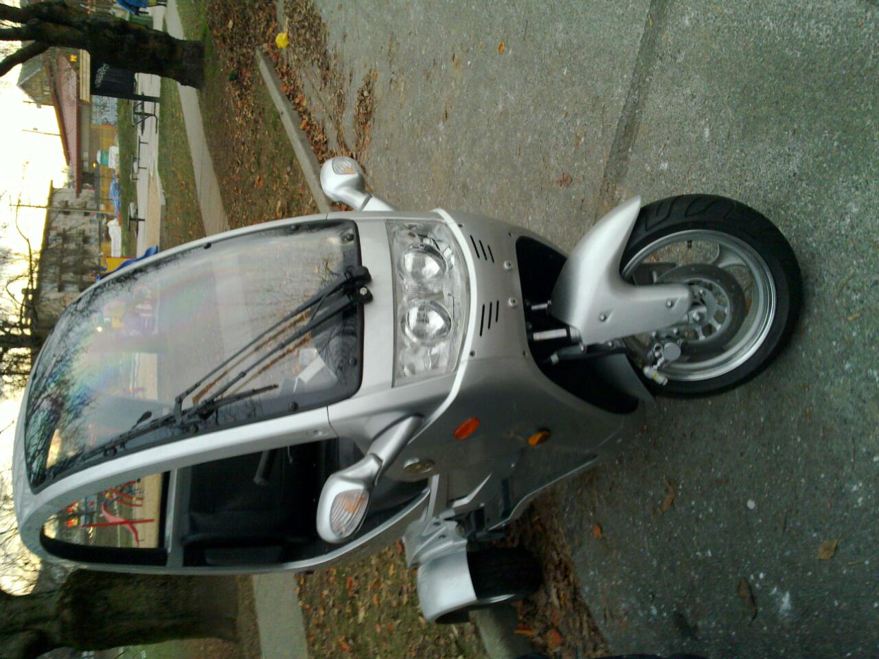 a silver vehicle is parked on the sidewalk