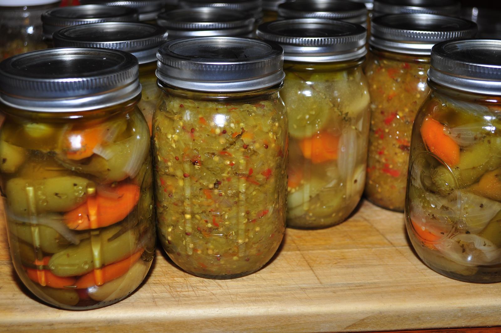 six jars are filled with pickles and carrots