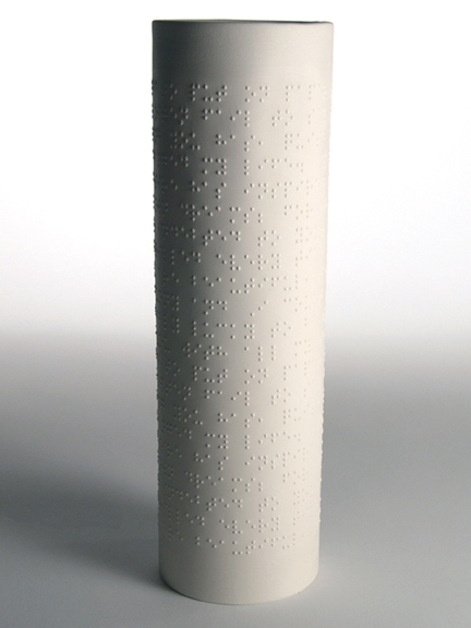 a white vase with very small holes on the top