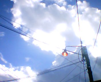 street light and electrical wires against a cloudy sky