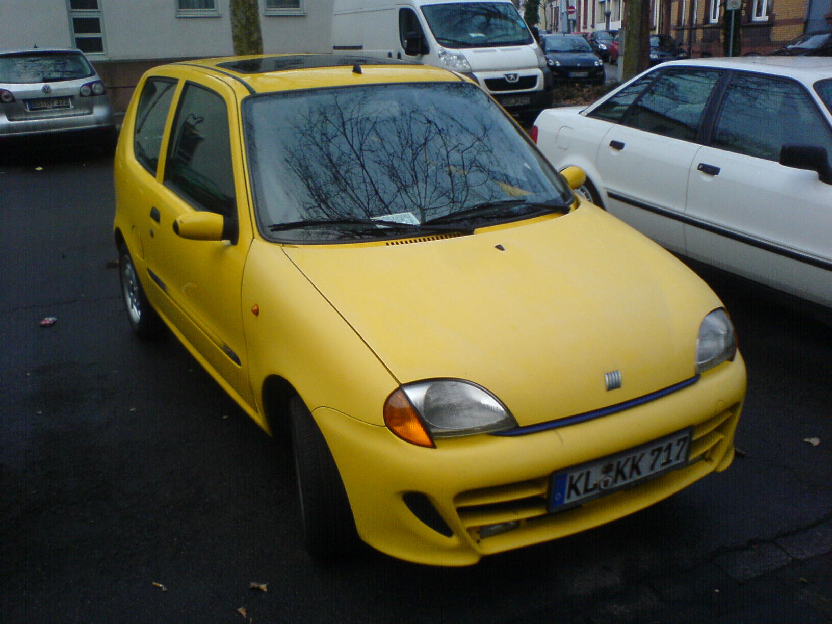 a yellow car is parked near other cars