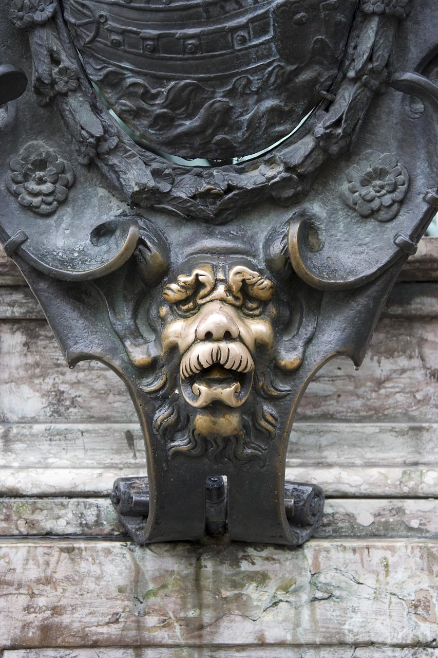 a golden lion heads on the front door of an old building