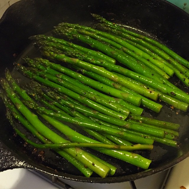 a pan filled with some green vegetables cooking