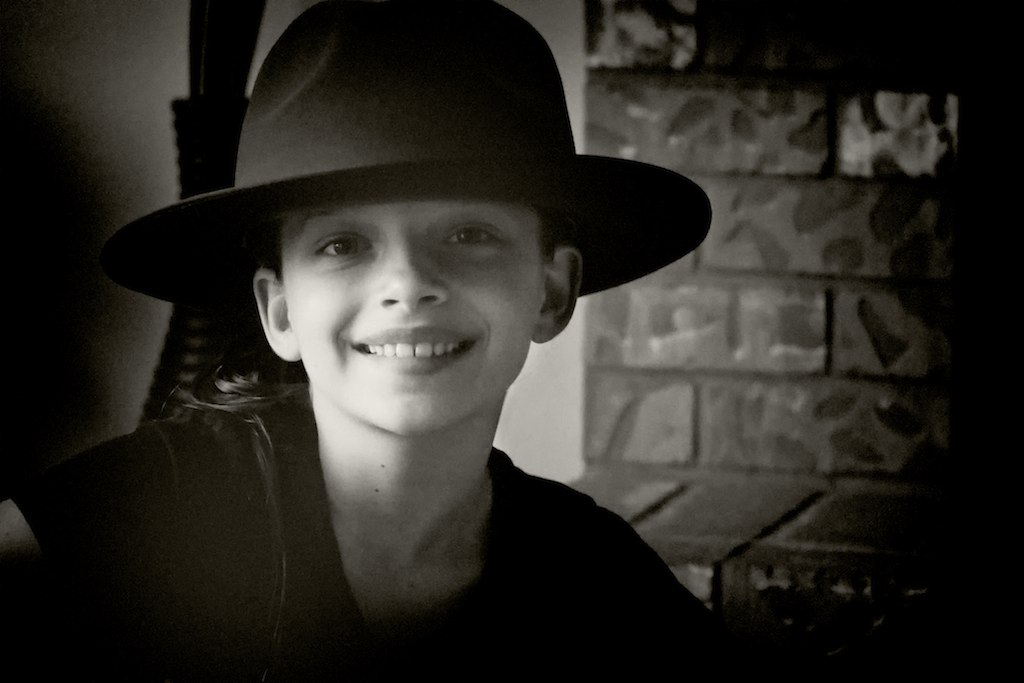 a black and white po of a girl wearing a hat