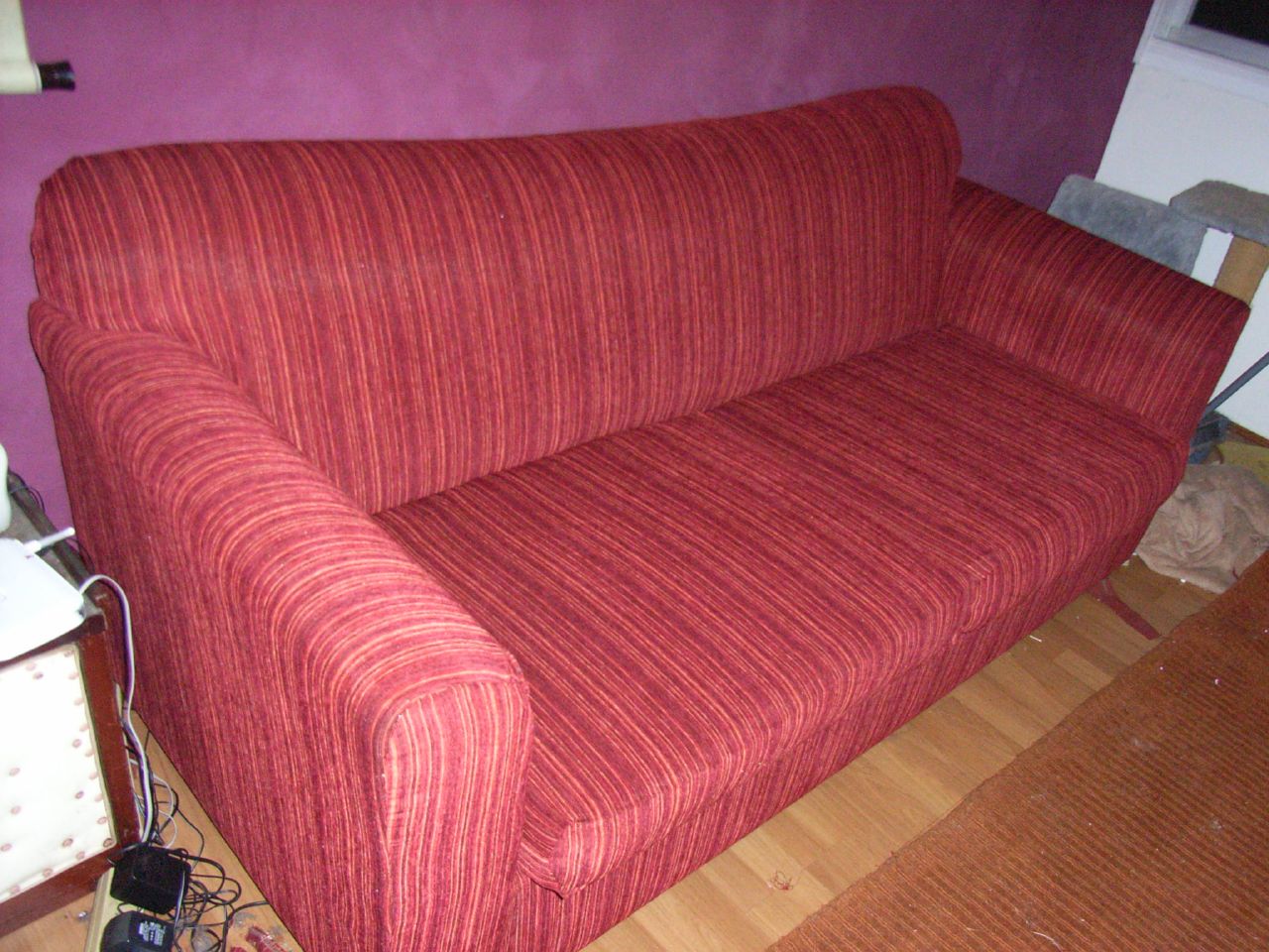 the couch is red and there are some pictures