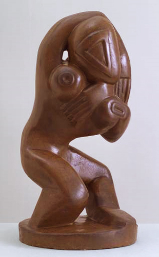 a large wood carving of a woman holding her head