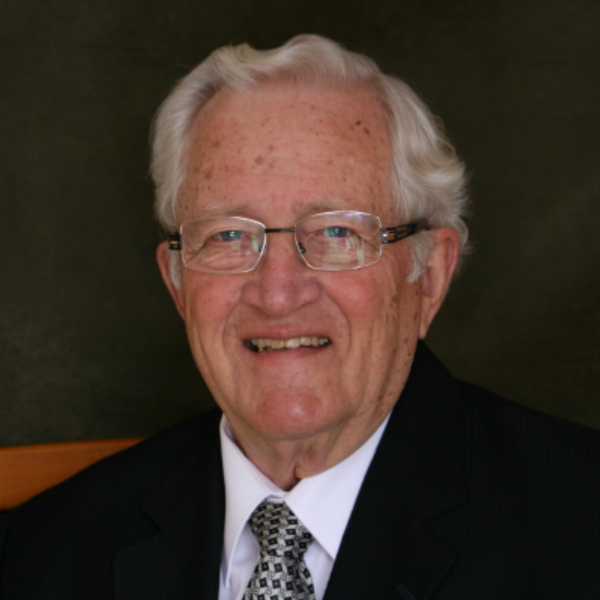 an older gentleman wearing glasses and a suit