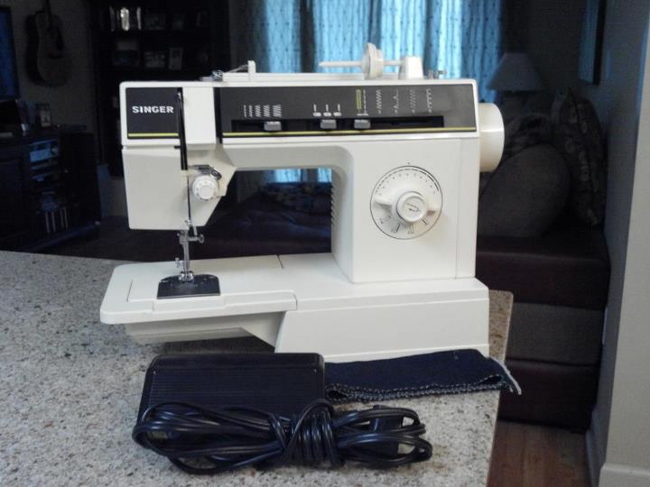 an open sewing machine with two cords on the side