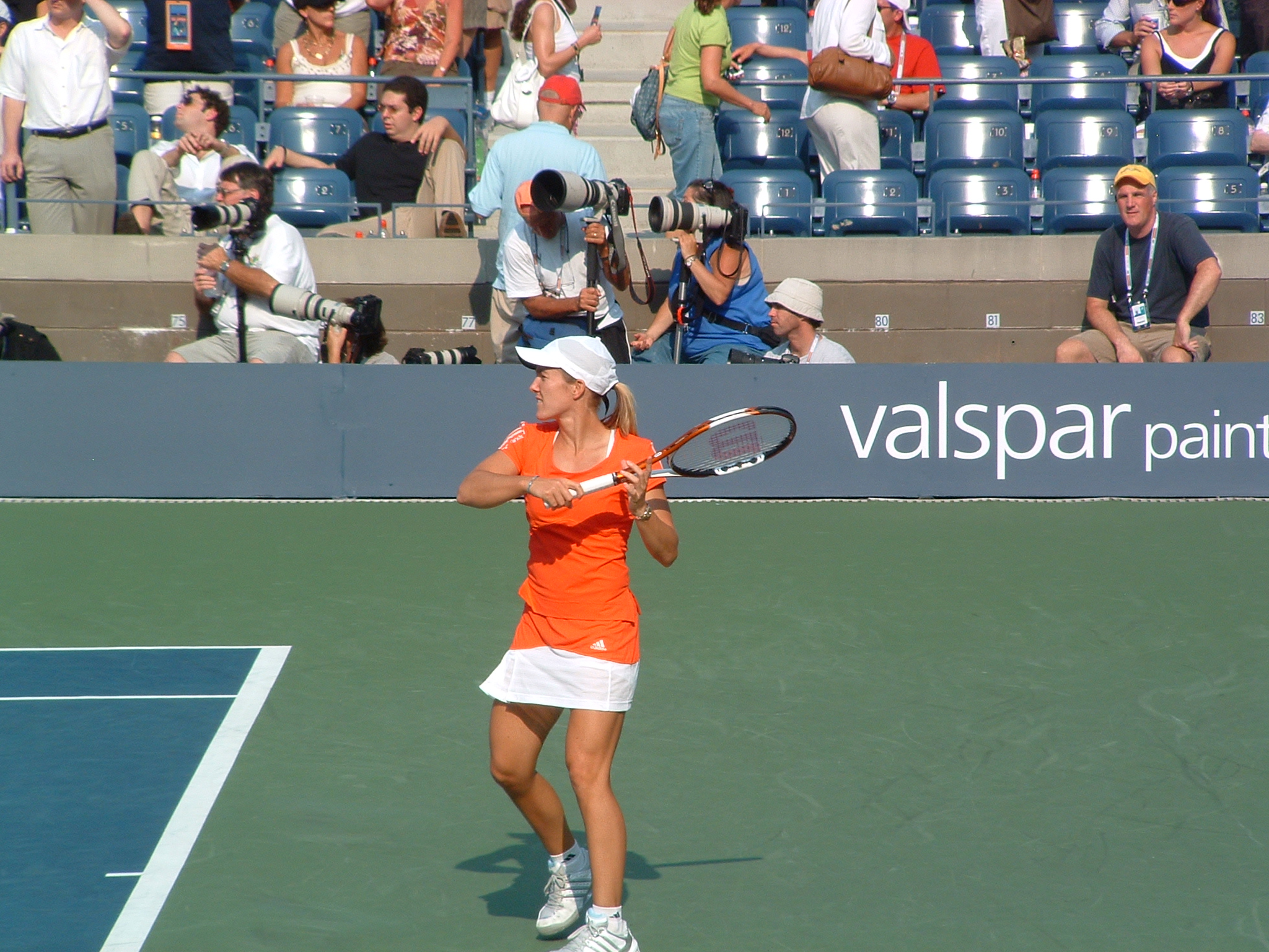a tennis player with an orange shirt is playing tennis
