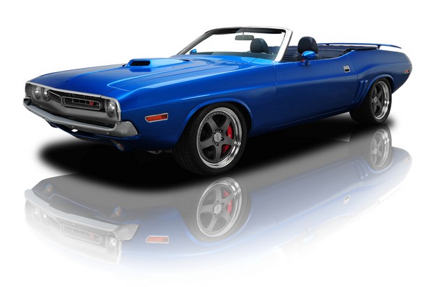 a blue muscle car sits on a reflective surface