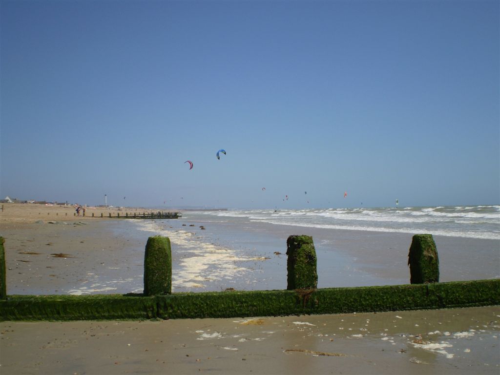 two kites are flying above the ocean near a beach