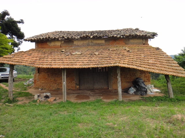 a brick and tile hut in a rural setting