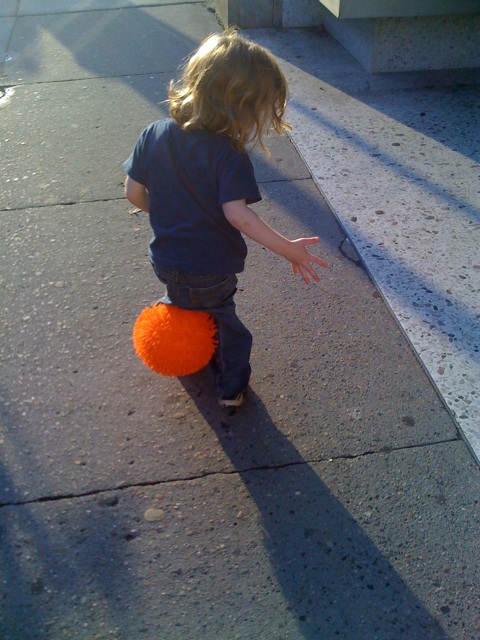 a little boy holding soing in his hand on the side walk