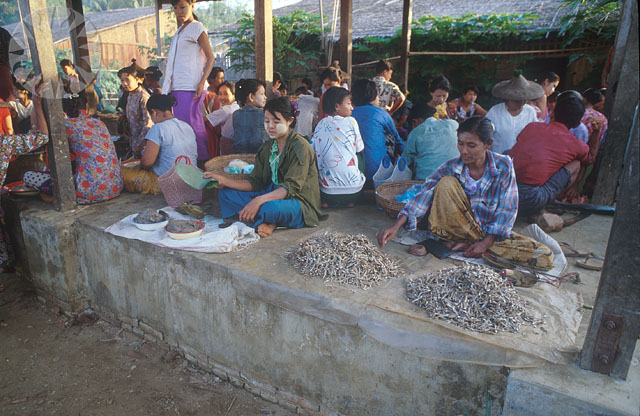 people sitting in a village with food around them