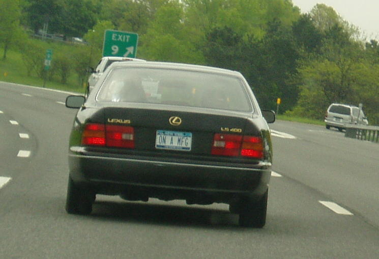 the back end of a car with an exit sign in the background