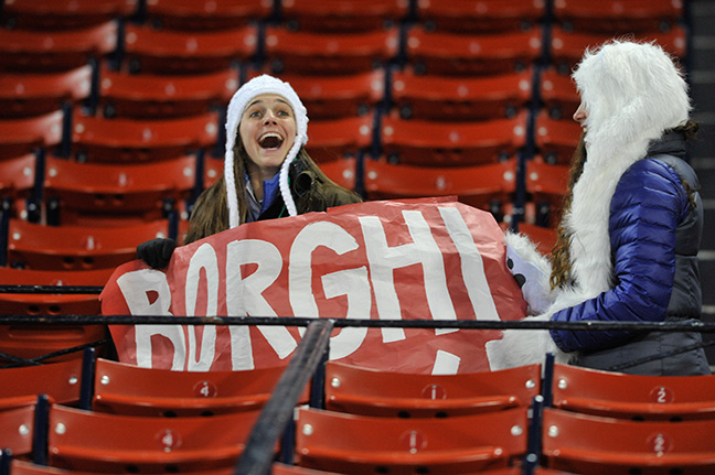 a person holding a sign and another person wearing a santa hat