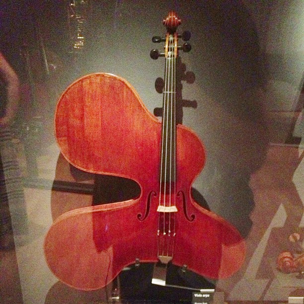 an older model violin in a glass case