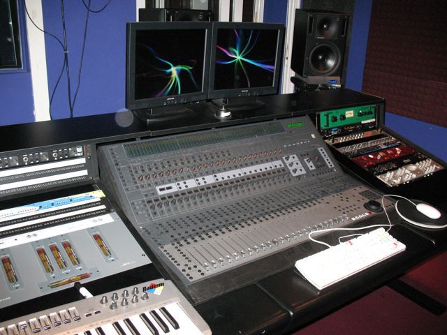 multiple monitors and equipment sitting on a table in front of speakers